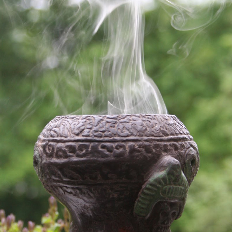 Rook stijgt op uit een rituele wierookschaal